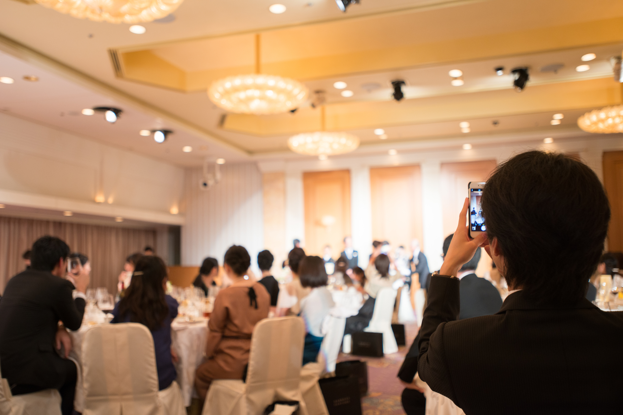 謝恩会で写真を撮る人