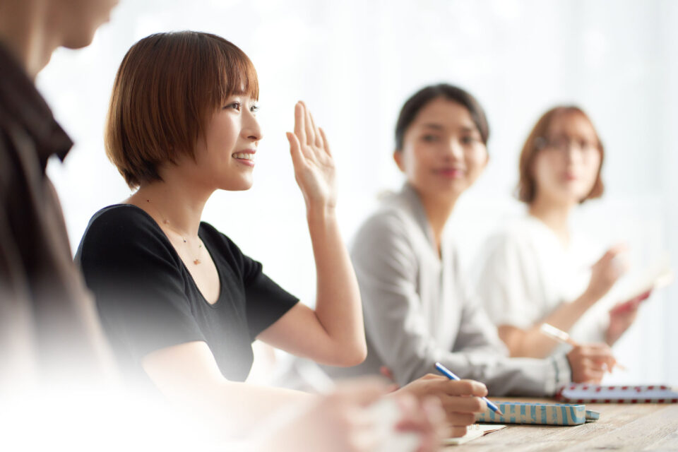 女性が手を挙げる様子