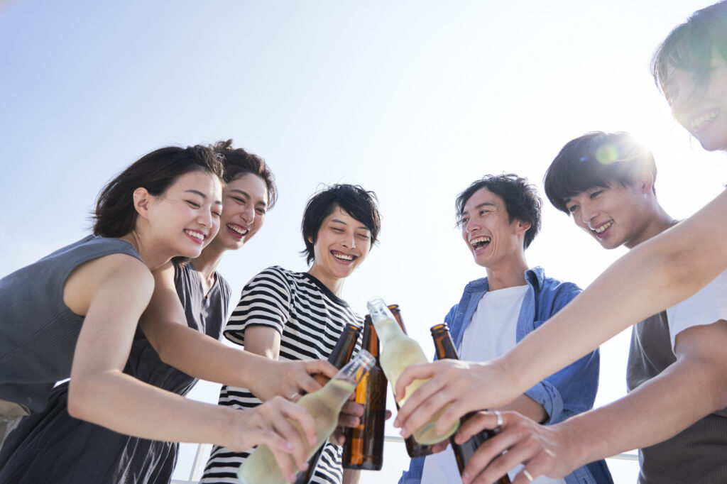若者が屋外で乾杯するイメージ