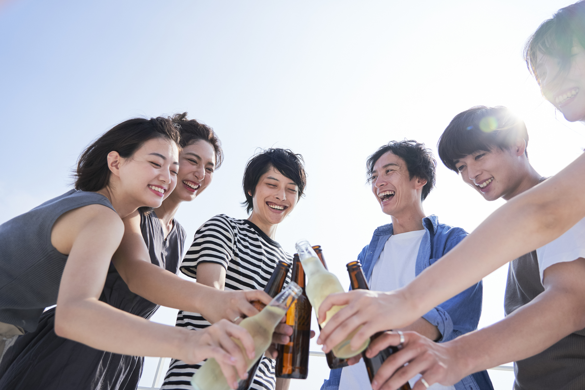 若者が屋外で乾杯するイメージ