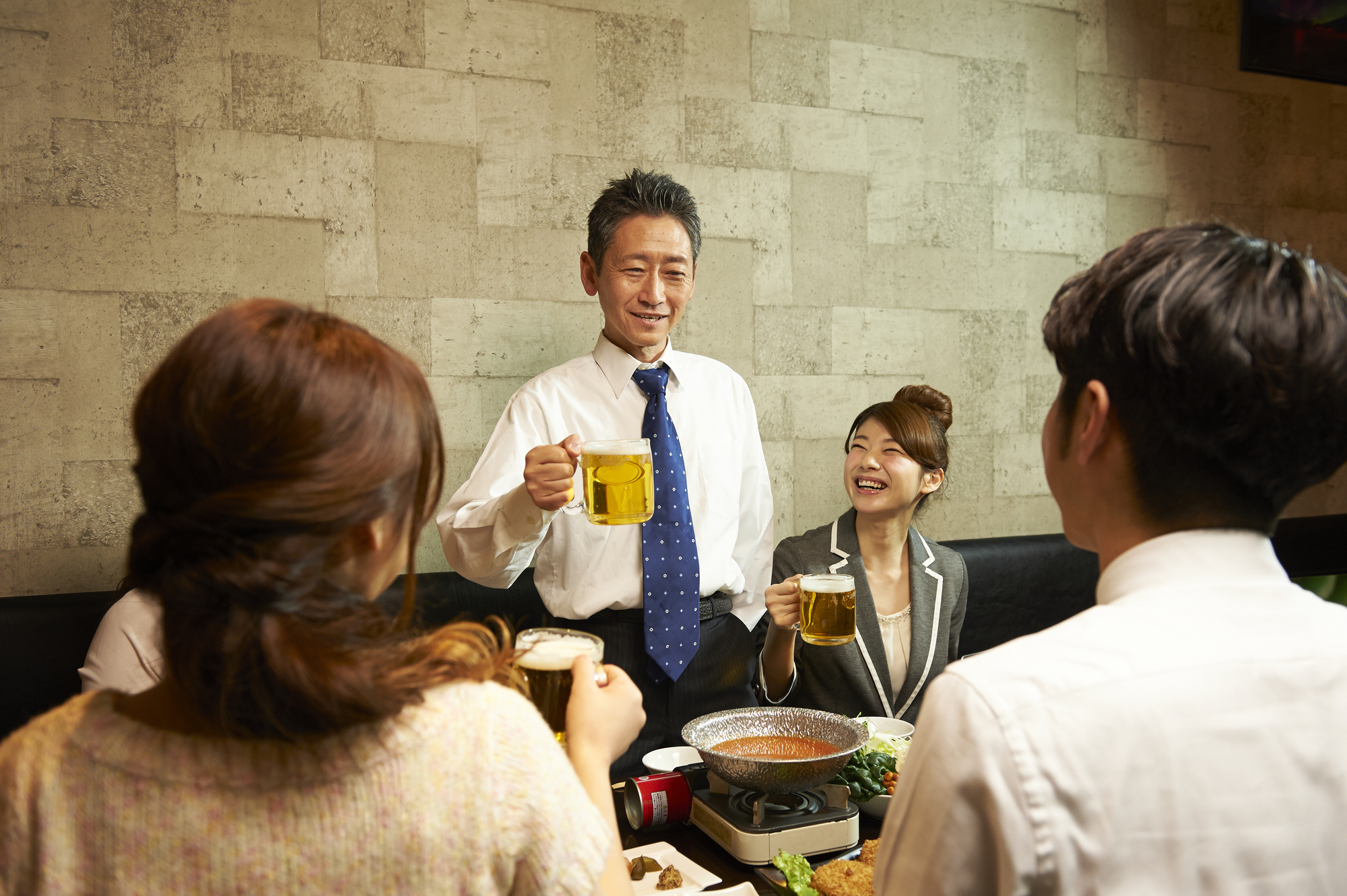 飲み会の席で挨拶をする様子