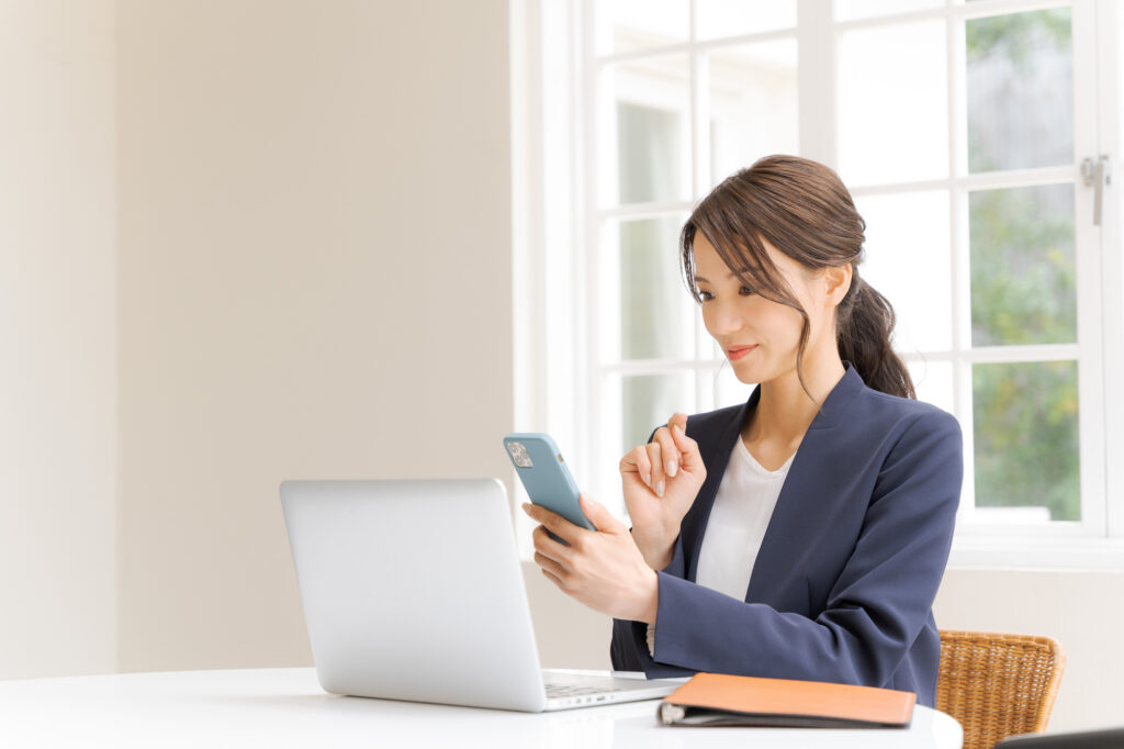 パソコンとスマホを見る女性