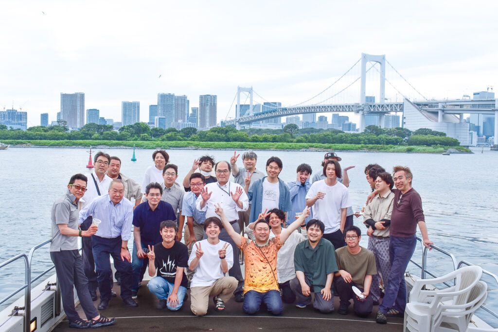 デッキでレインボーブリッジバックに集合写真